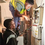 Power stabilisation project. Technicians installing Victron Power backup and new power cables in a server room