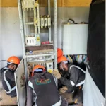 Power project. Technicians installing an electrical bypass panel for the new AVR supplied.