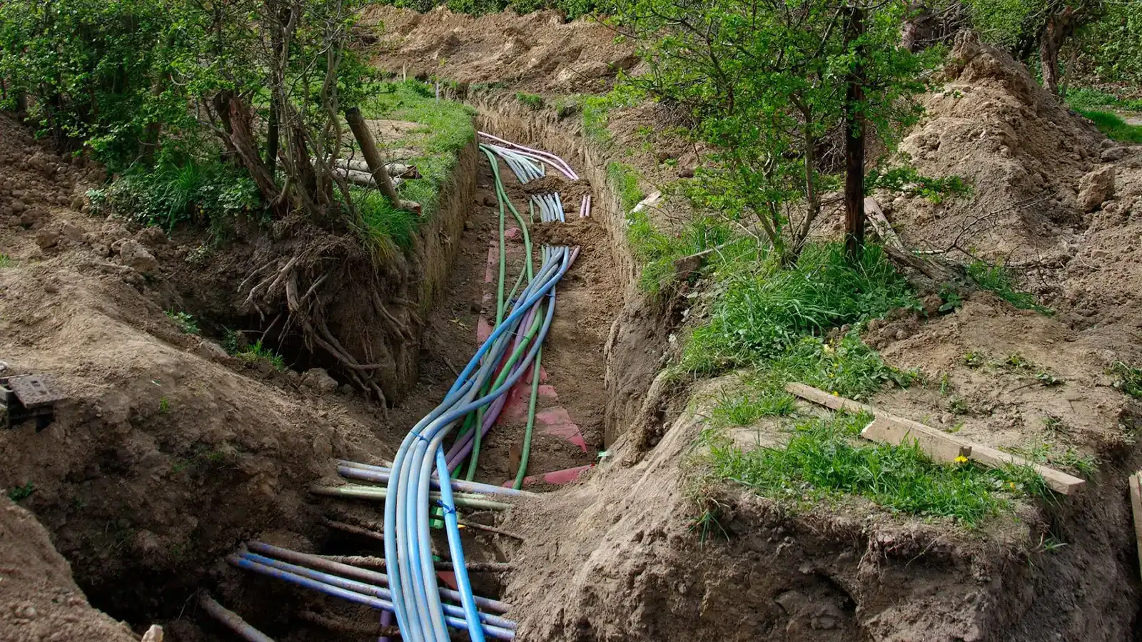 Underground fibre optic cable installation in trench for long-distance network infrastructure deployment.