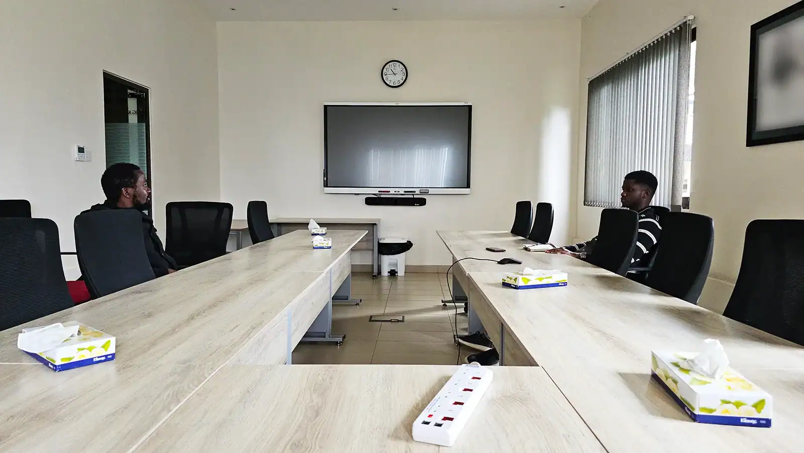 Interactive screen and video conferencing camera in a modern boardroom for enterprise collaboration and virtual meetings.
